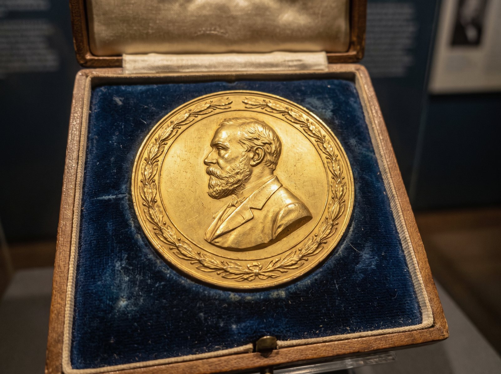 A gold prize medal displayed in a museum case